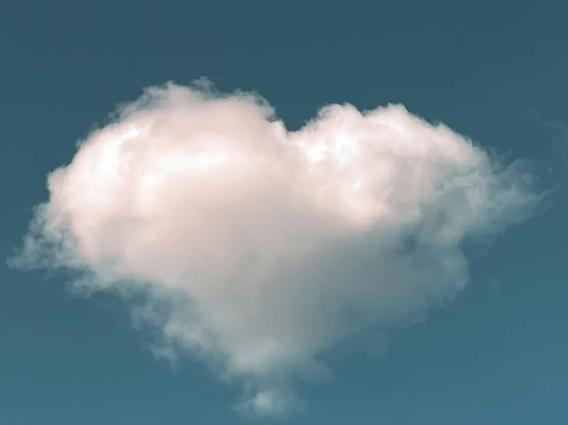 A heart-shaped cloud in a blue sky